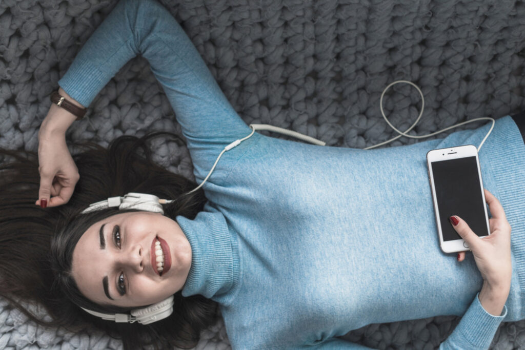 cheerful-woman-listening-music-sofa (1) (2)