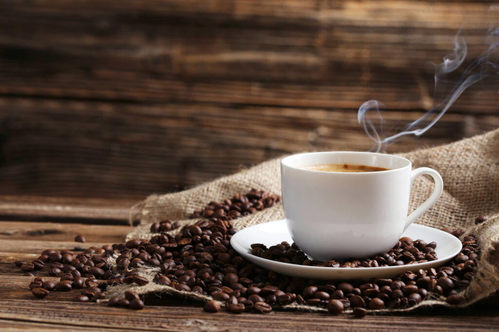 steaming+cup+of+coffee+with+spilt+coffee+beans
